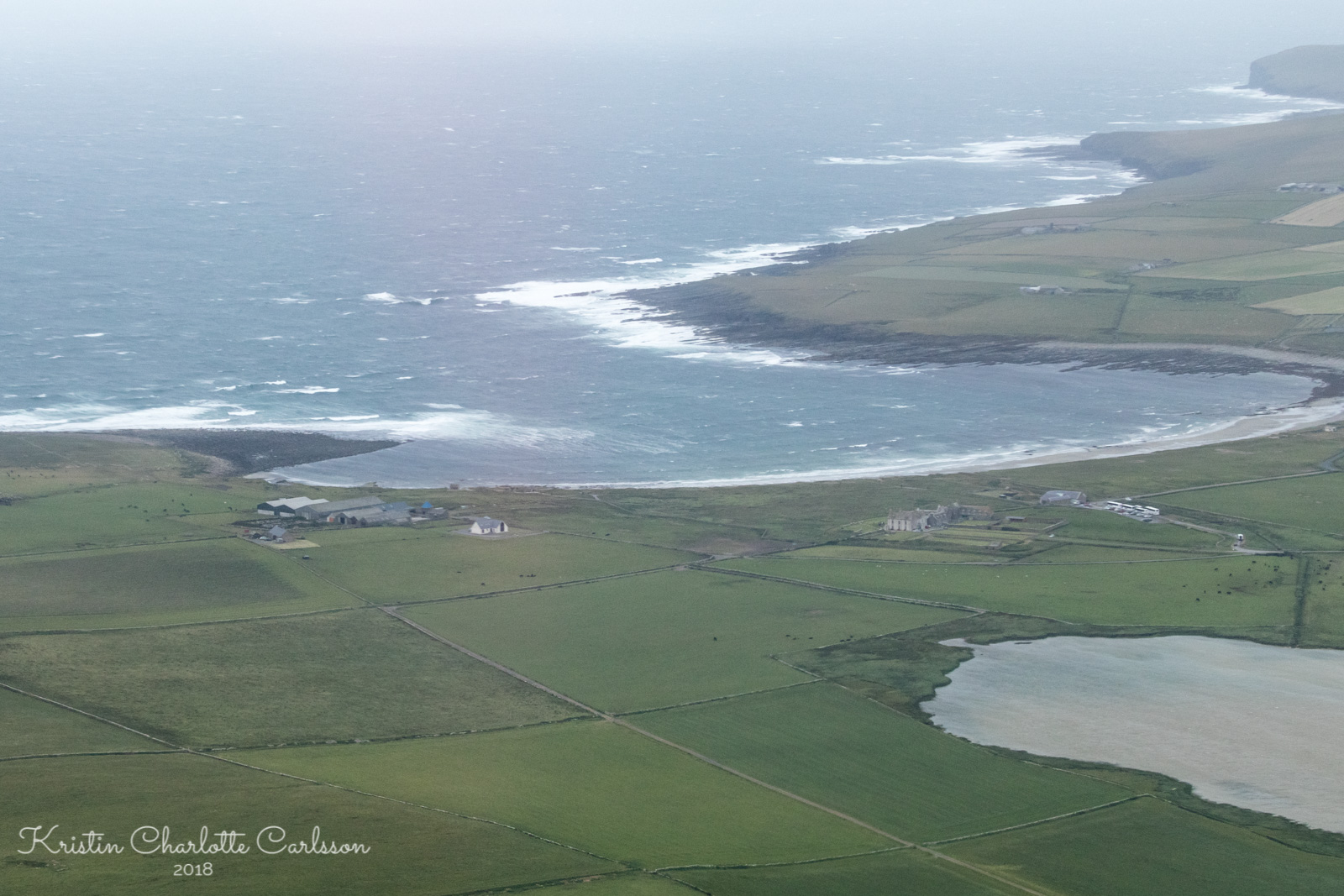 Utsikt over Bay of Skaill med Skara Brae i forgrunnen.